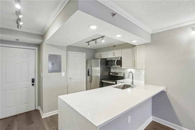 kitchen featuring appliances with stainless steel finishes, sink, white cabinets, and kitchen peninsula