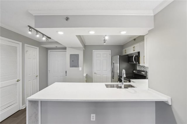 kitchen with sink, appliances with stainless steel finishes, white cabinetry, tasteful backsplash, and kitchen peninsula