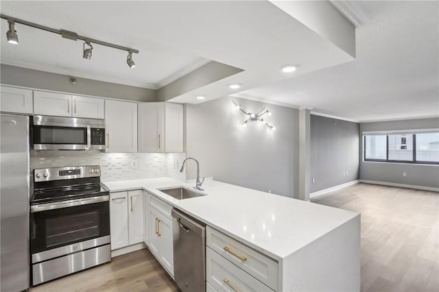 kitchen with sink, kitchen peninsula, and appliances with stainless steel finishes