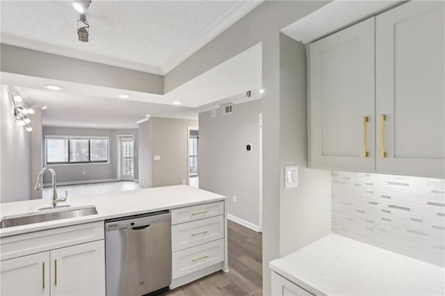 kitchen featuring tasteful backsplash, dishwasher, sink, and white cabinets