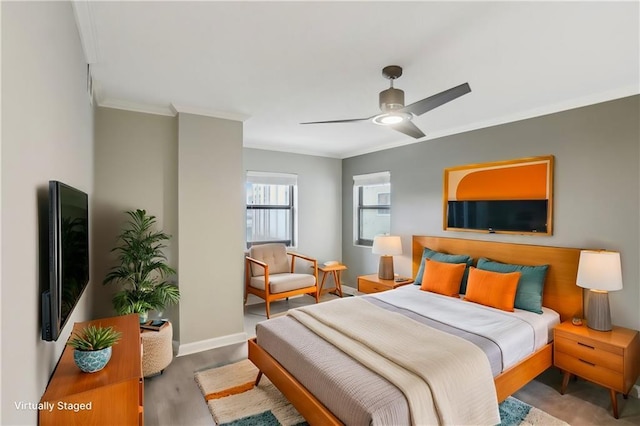 bedroom featuring hardwood / wood-style floors, crown molding, and ceiling fan