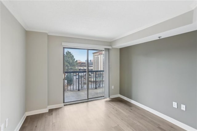 empty room with crown molding and light hardwood / wood-style flooring