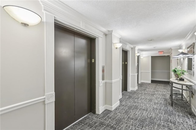 hallway featuring crown molding, a textured ceiling, and dark colored carpet