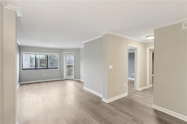 unfurnished room featuring ornamental molding and light wood-type flooring