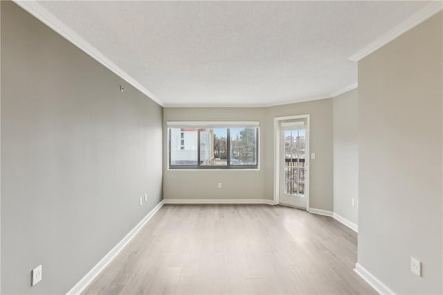 empty room with crown molding, a textured ceiling, and light hardwood / wood-style floors