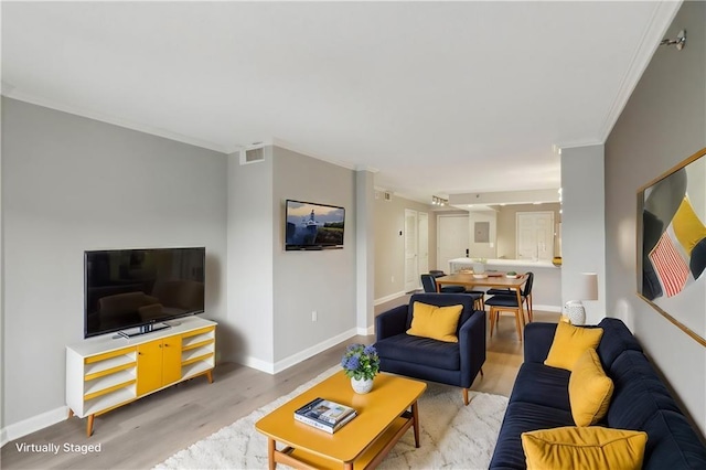 living room featuring crown molding and light hardwood / wood-style flooring