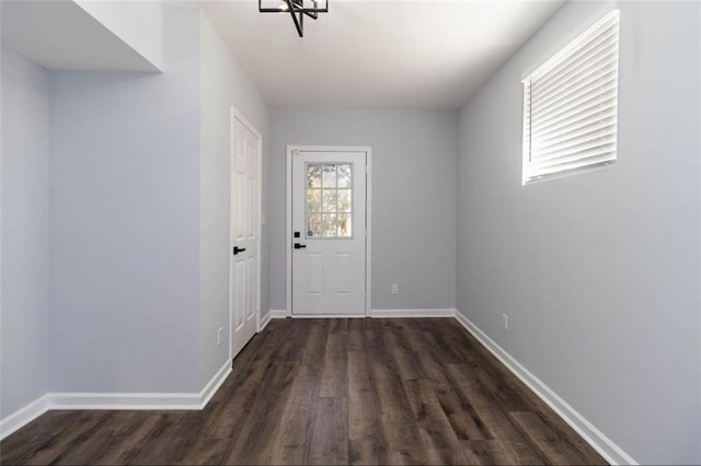 entryway with an inviting chandelier and dark hardwood / wood-style flooring