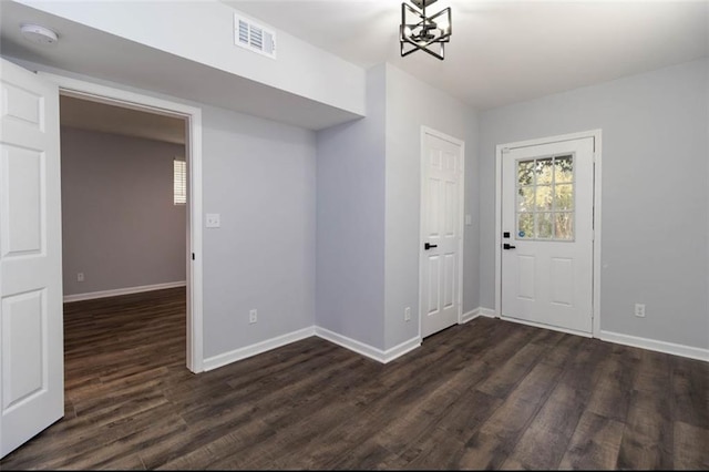 foyer entrance with dark wood-type flooring and a chandelier