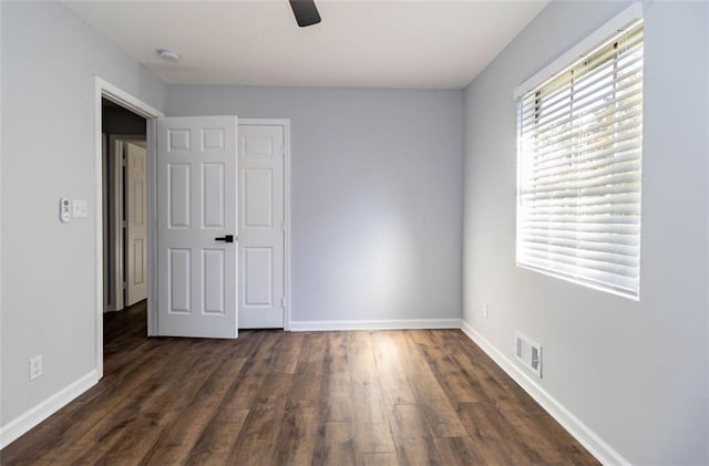 unfurnished bedroom with a closet, ceiling fan, and dark hardwood / wood-style flooring