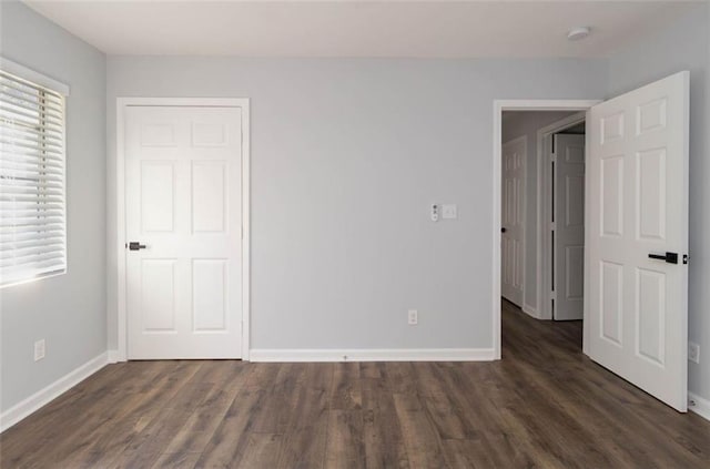 unfurnished bedroom with dark hardwood / wood-style floors