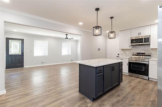 kitchen featuring a kitchen island, stainless steel appliances, light wood-type flooring, white cabinets, and ceiling fan