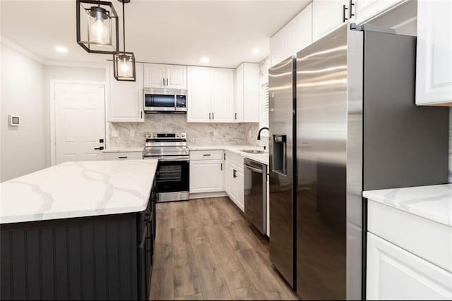 kitchen with white cabinets, dark hardwood / wood-style flooring, appliances with stainless steel finishes, pendant lighting, and sink