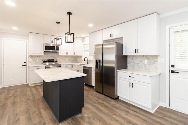 kitchen featuring stainless steel appliances, a kitchen island, and white cabinets