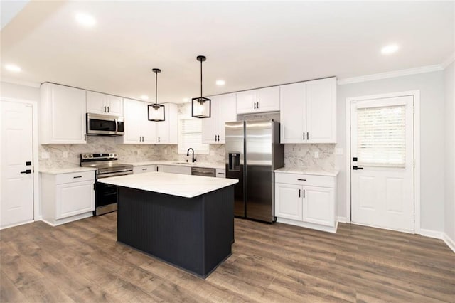 kitchen featuring stainless steel appliances, sink, a kitchen island, and white cabinets