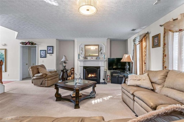 living room featuring visible vents, carpet floors, a lit fireplace, and a textured ceiling