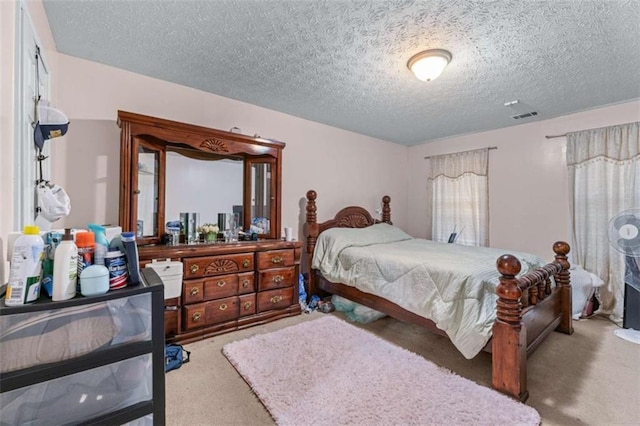 bedroom with visible vents, a textured ceiling, and carpet