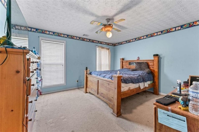 carpeted bedroom featuring baseboards, a ceiling fan, visible vents, and a textured ceiling