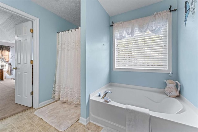 full bathroom with curtained shower, tile patterned floors, a bath, and a textured ceiling