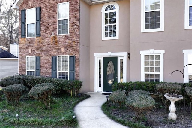 property entrance with stone siding and stucco siding