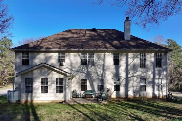 back of house with a yard, a chimney, and a patio area