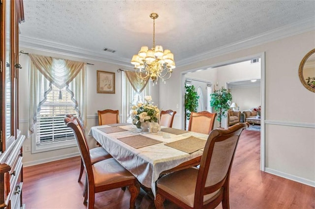 dining room featuring crown molding, a notable chandelier, and wood finished floors