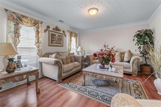 living area with crown molding, wood finished floors, visible vents, and a textured ceiling