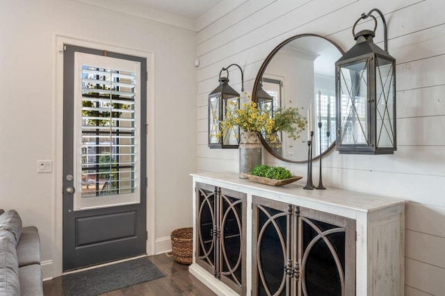 doorway to outside featuring ornamental molding and dark hardwood / wood-style floors