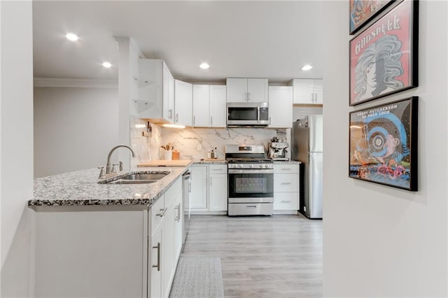 4417 Village Square Ln, Stone Mountain, GA 30083 - kitchen featuring appliances with stainless steel finishes, ornamental molding, light stone counters, white cabinets, and light wood-type flooring