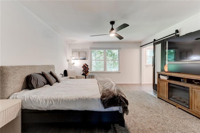 4417 Village Square Ln, Stone Mountain, GA 30083 - bedroom featuring light wood-style flooring, a barn door, crown molding, and a ceiling fan