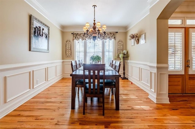 dining room featuring a notable chandelier, crown molding, and light hardwood / wood-style flooring