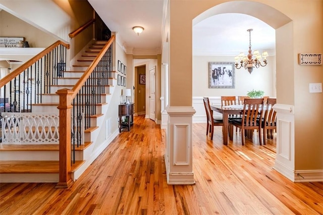 interior space featuring hardwood / wood-style floors, ornamental molding, and an inviting chandelier