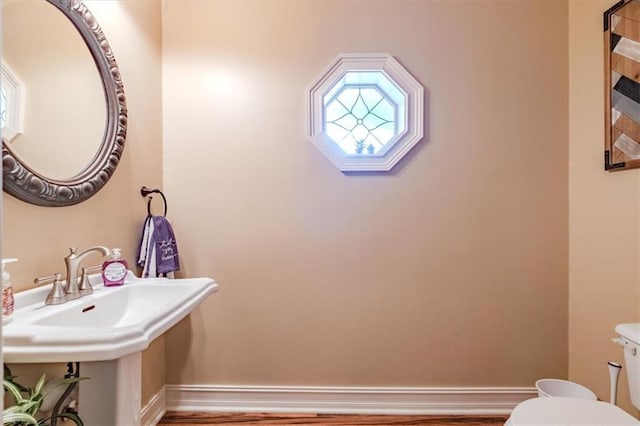 bathroom featuring wood-type flooring and toilet