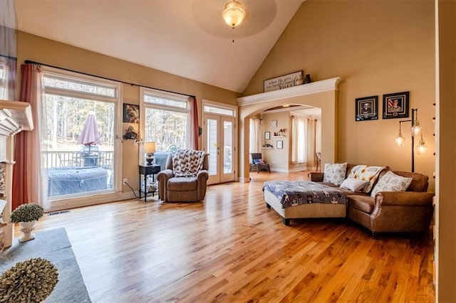 living room with ceiling fan, french doors, high vaulted ceiling, and light wood-type flooring