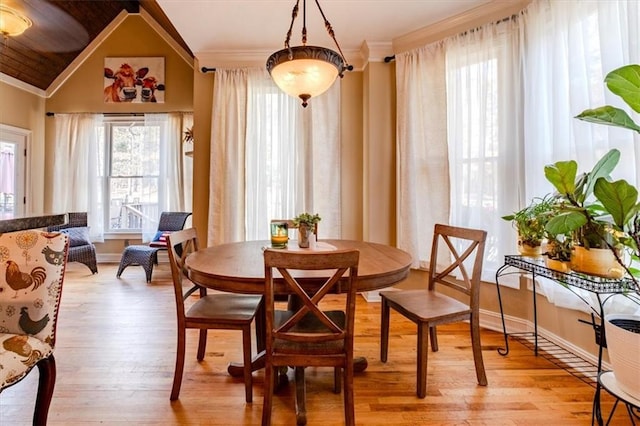 dining room with vaulted ceiling and light wood-type flooring