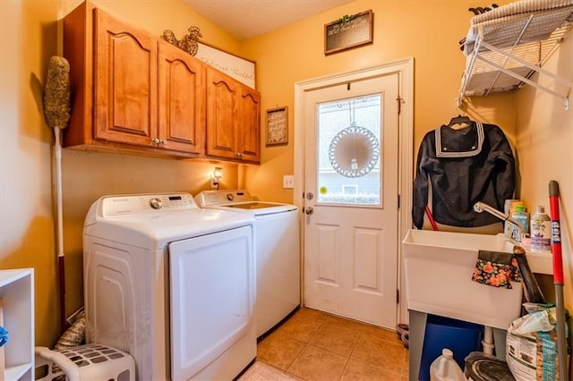 washroom with washer and dryer, cabinets, and light tile patterned flooring