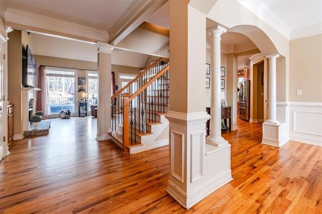 stairway featuring hardwood / wood-style floors, crown molding, and beamed ceiling