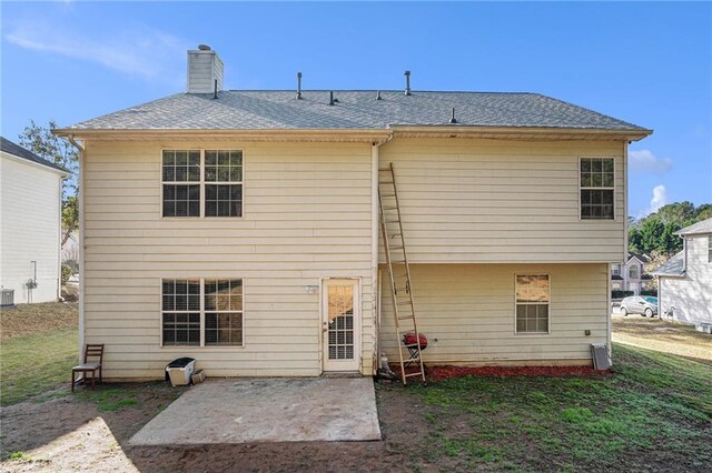 rear view of house with a lawn and a patio area