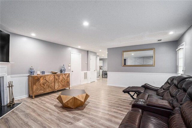 living room with light hardwood / wood-style floors and a textured ceiling