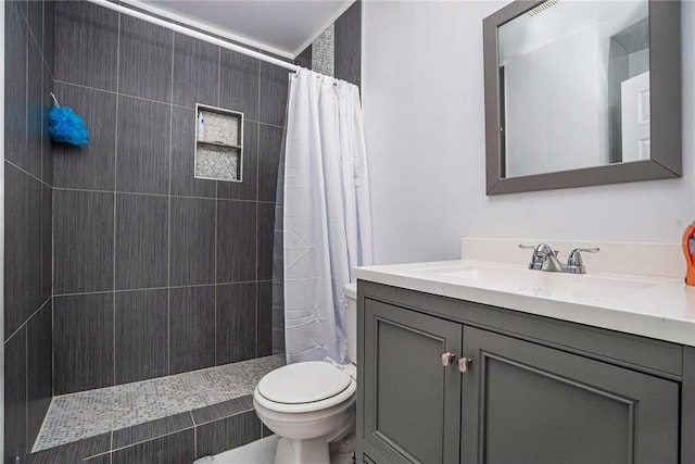 bathroom featuring toilet, vanity, and walk in shower