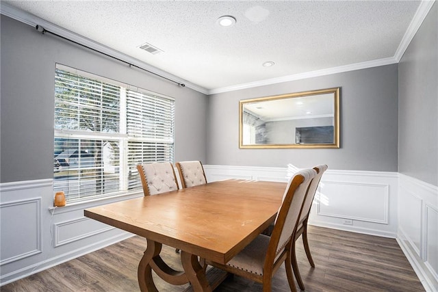 dining space featuring a textured ceiling, dark hardwood / wood-style flooring, and crown molding