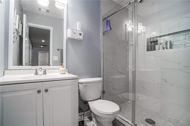 bathroom featuring vanity, toilet, and a shower with door