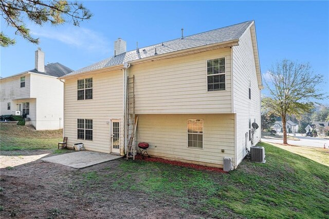 rear view of property with a patio area, a yard, and central AC