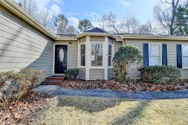 doorway to property featuring a lawn