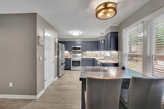 3202 Ivy Station Way, Duluth, GA 30096 - kitchen with stainless steel appliances, a sink, a peninsula, backsplash, and light wood-type flooring