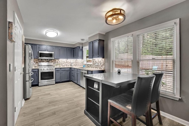 3202 Ivy Station Way, Duluth, GA 30096 - kitchen featuring stainless steel appliances, a sink, backsplash, light countertops, and light wood-type flooring