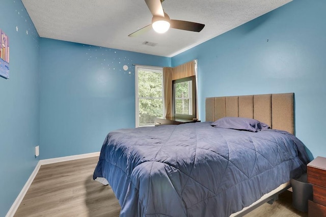 3202 Ivy Station Way, Duluth, GA 30096 - bedroom with wood finished floors, a textured ceiling, baseboards, and ceiling fan