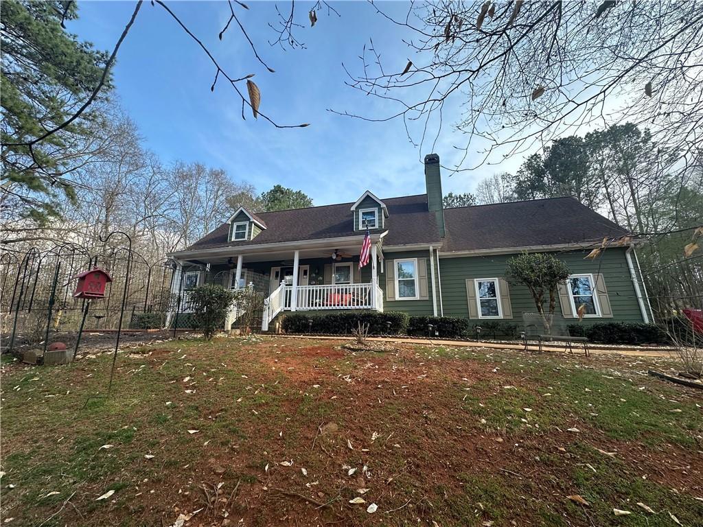cape cod home featuring covered porch and a chimney