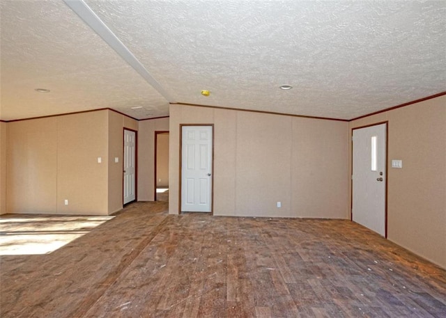 spare room featuring a textured ceiling, hardwood / wood-style flooring, and lofted ceiling