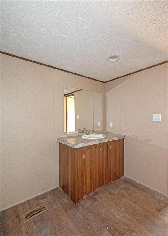 interior space with hardwood / wood-style floors, vanity, and a textured ceiling