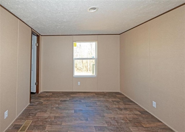 unfurnished bedroom featuring a textured ceiling, dark hardwood / wood-style floors, and ornamental molding